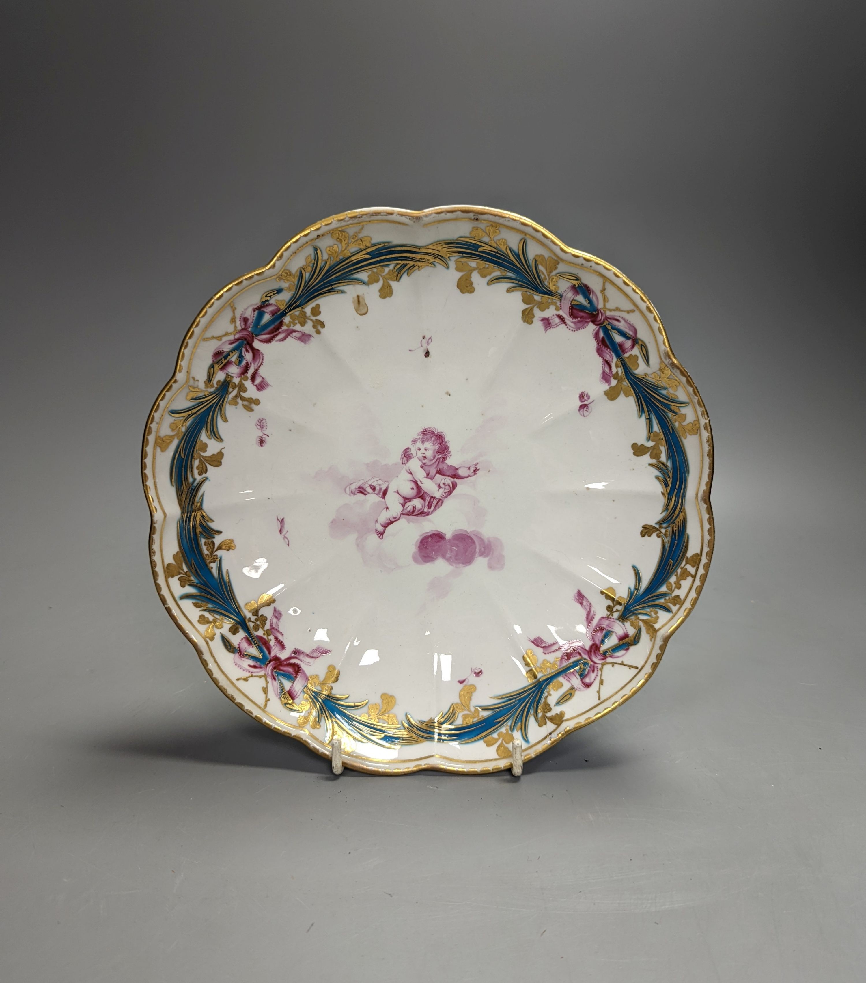A Chelsea-Derby circular dish painted in puce with a cherub floating on a cloud by Richard Askew, c.1775, 22cm